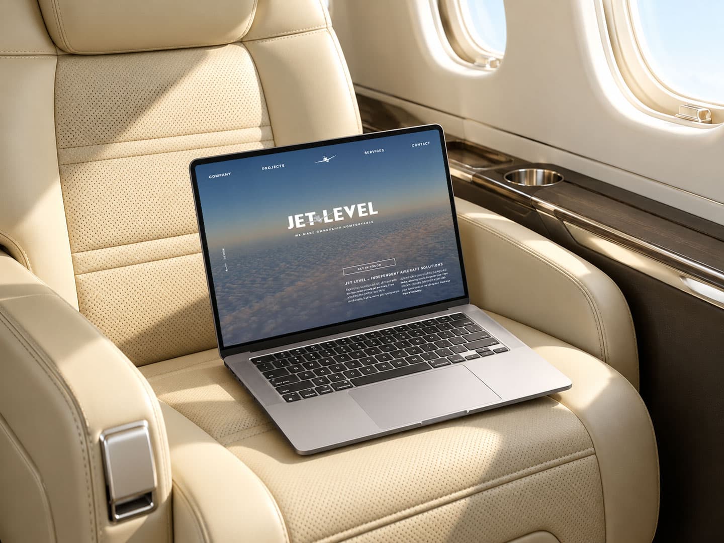 Laptop mit der JetLevel-Website auf einem hellen Ledersitz im Innenraum eines Privatjets